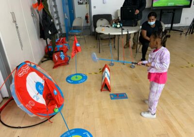 Young girl hitting a ball onto a round target.